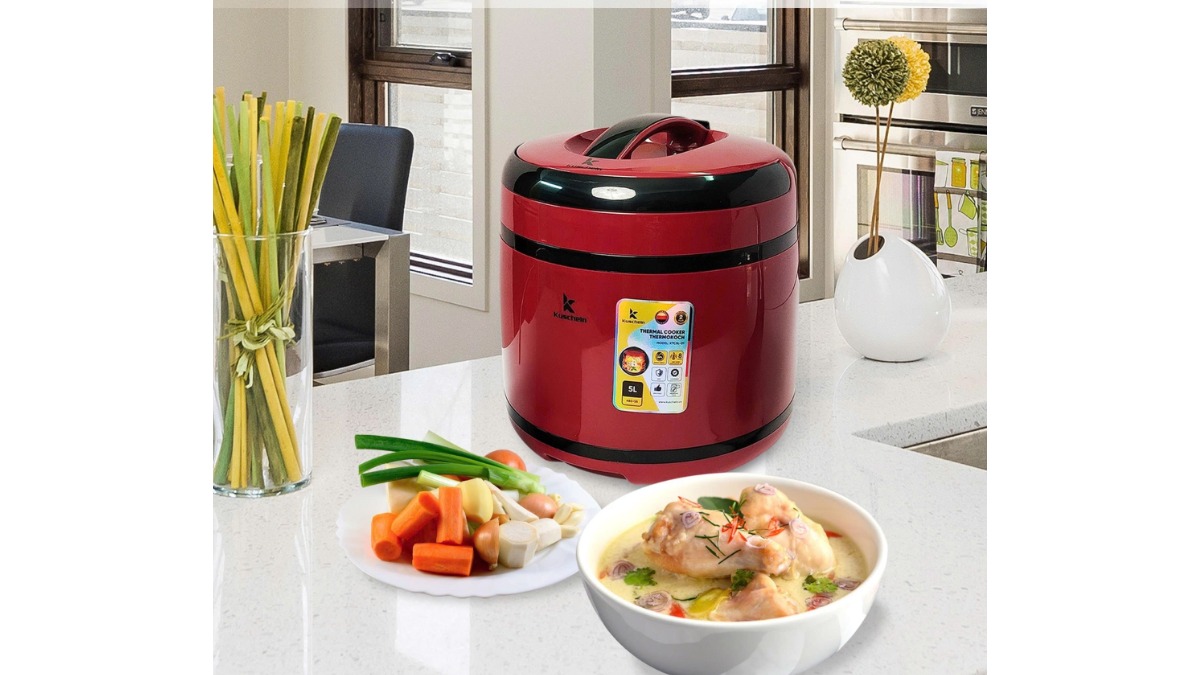 Nồi ủ nhiệt Kuscheln 5L vỏ ngoài màu đỏ đặt cạnh bát canh gà và đĩa rau củ